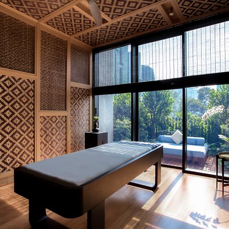 더 루마 호텔 앤 레지던스 쿠알라룸푸르 외부 사진 The photo displays a tranquil room designed for relaxation or therapy. The room features a massage table centered in the space, with elegant wooden accents. The walls are adorned with intricate geometric patterns, contributing to a serene atmosphere.