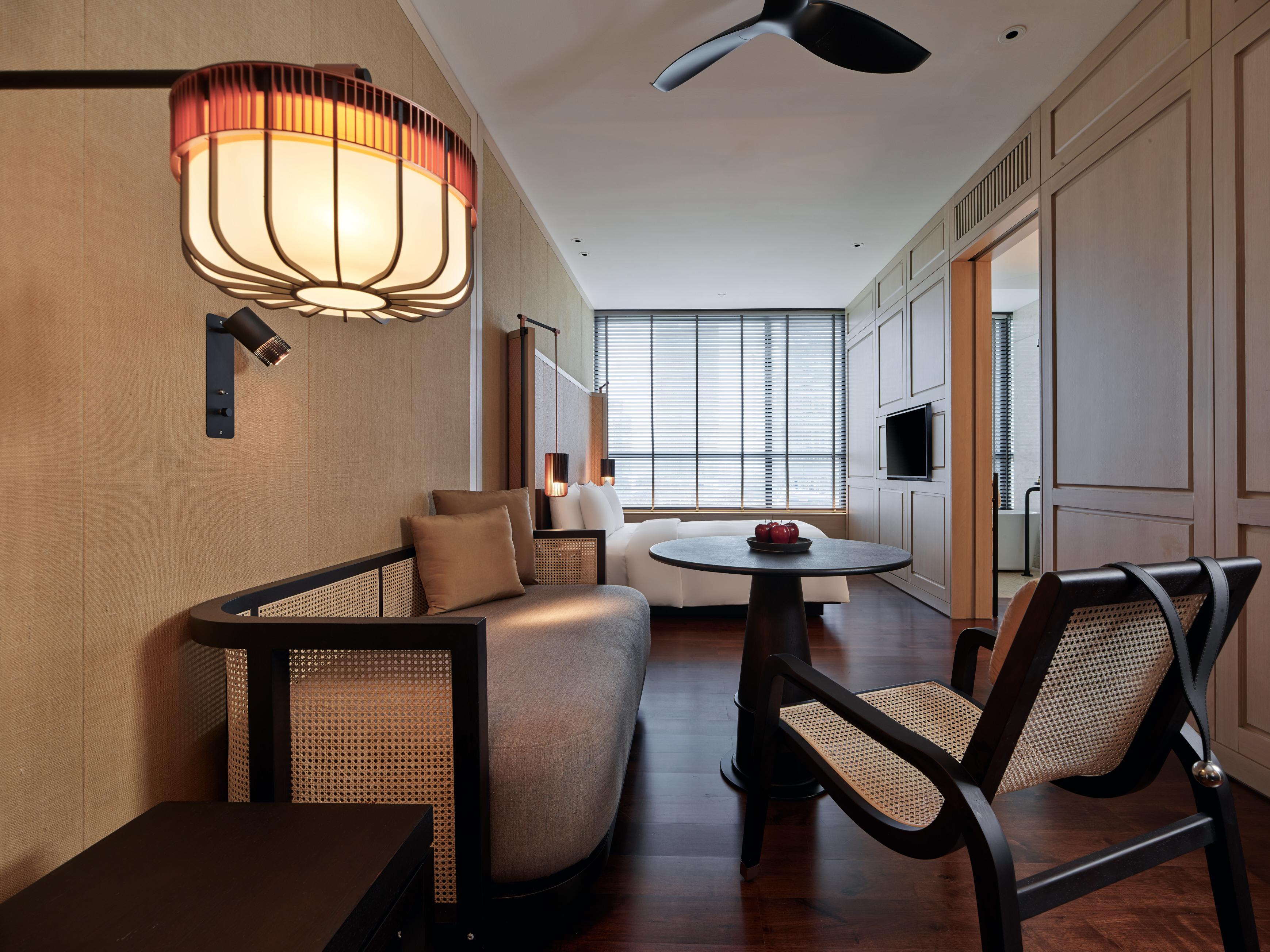 더 루마 호텔 앤 레지던스 쿠알라룸푸르 외부 사진 The photo shows a stylish and modern interior of a hotel room or a living space. The decor features warm tones and natural materials, with a wall finished in light wood or beige. 

In the foreground, there is a round table with a small decorative ite