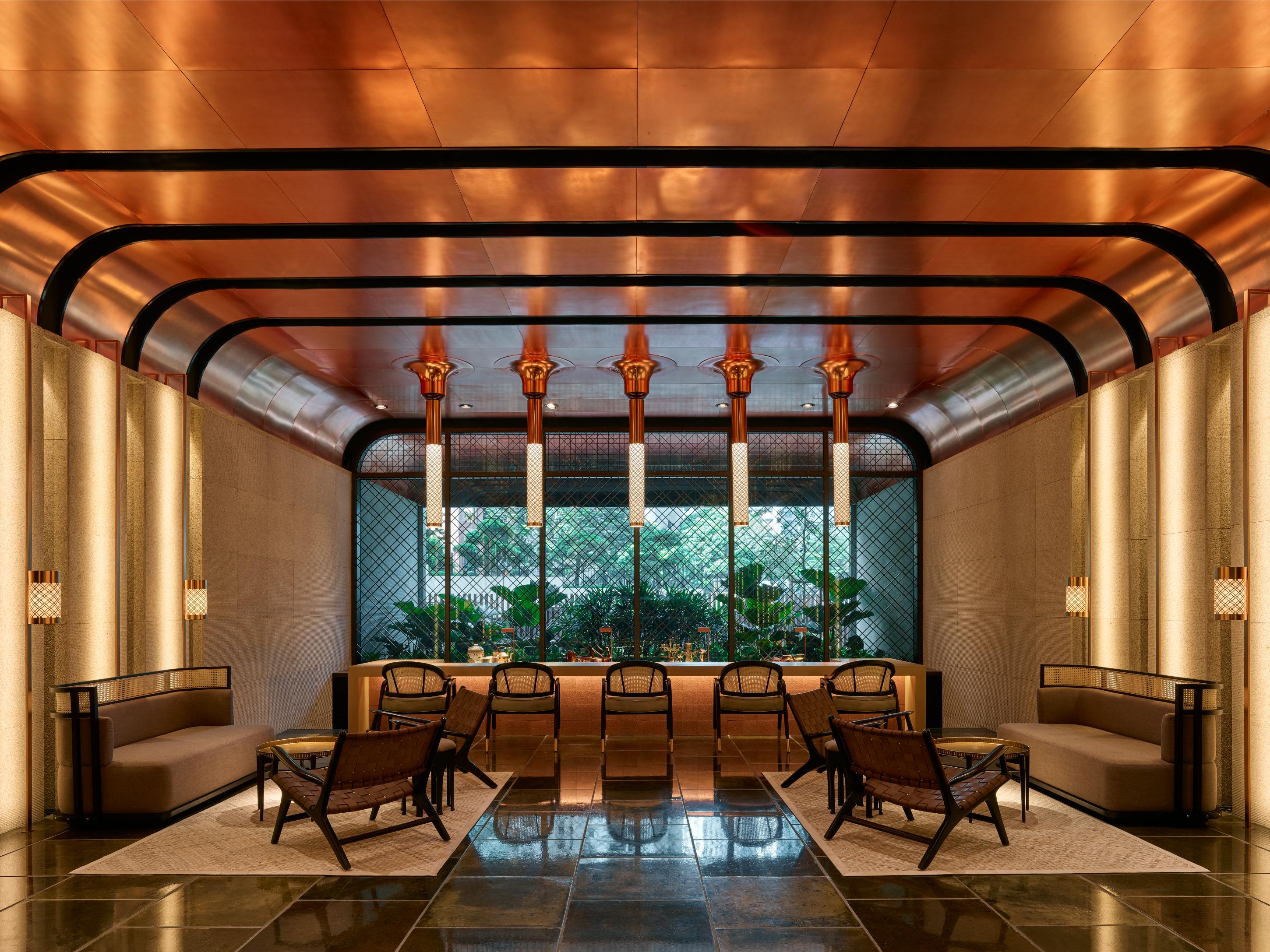 더 루마 호텔 앤 레지던스 쿠알라룸푸르 외부 사진 The image shows a stylish interior space with a modern and elegant design. The walls have a sleek, warm-toned finish, and there are large windows that provide natural light. The ceiling features striking architectural lines, likely in a metallic mate