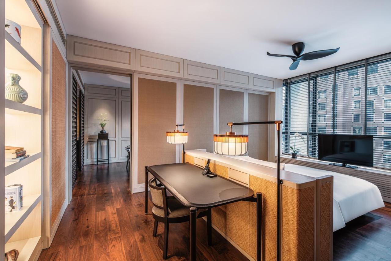 더 루마 호텔 앤 레지던스 쿠알라룸푸르 외부 사진 The photo shows a modern, elegantly designed bedroom. The room features wooden flooring and a spacious layout with a large window that allows natural light to fill the space. There is a comfortable bed situated against one wall, and a stylish desk wi