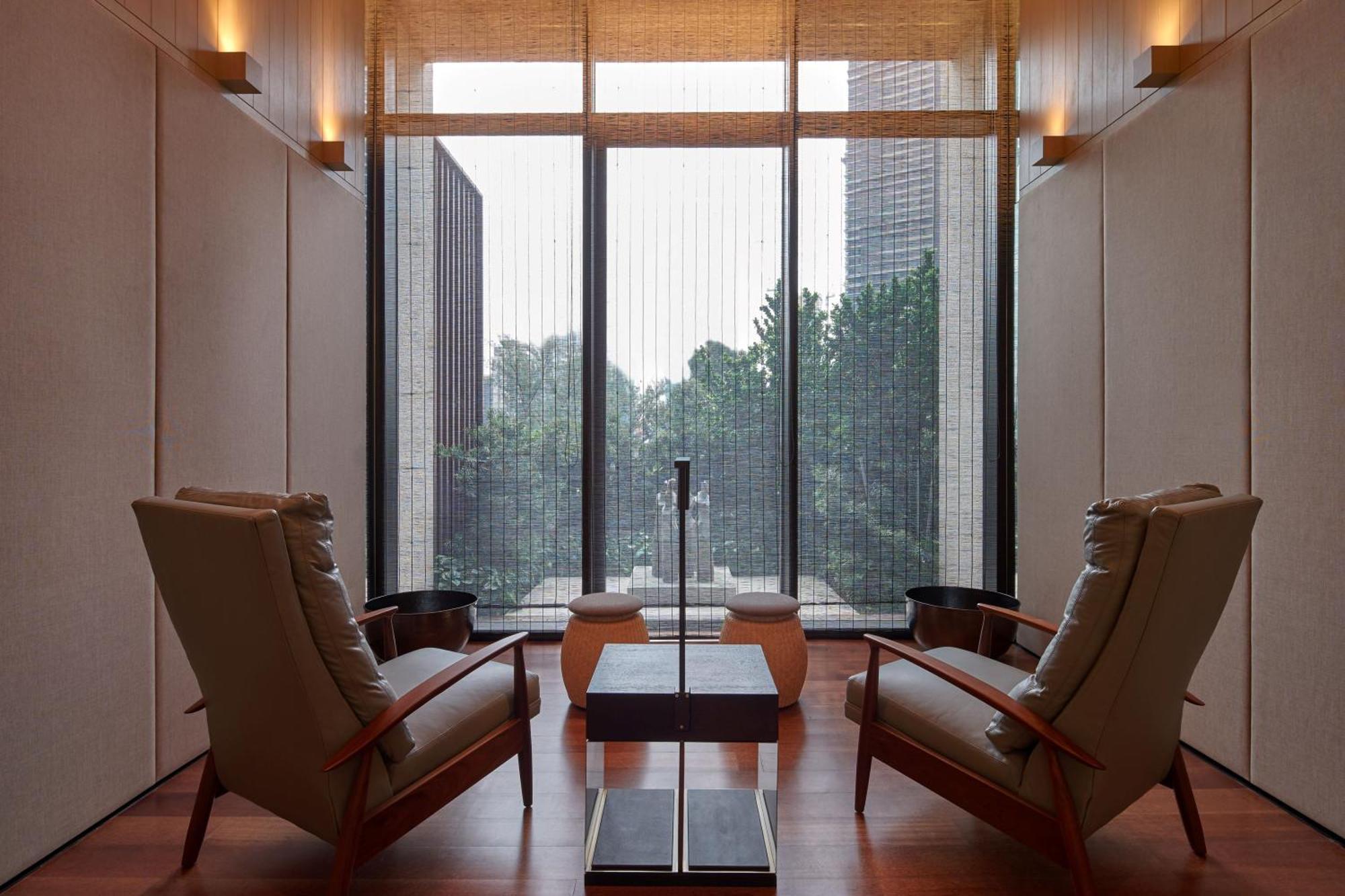 더 루마 호텔 앤 레지던스 쿠알라룸푸르 외부 사진 The photo depicts a minimalist interior space, featuring two stylish chairs positioned across from each other. Between them, there's a sleek table with a simple design. The walls are finished with a light color, contributing to a serene ambiance. Lar
